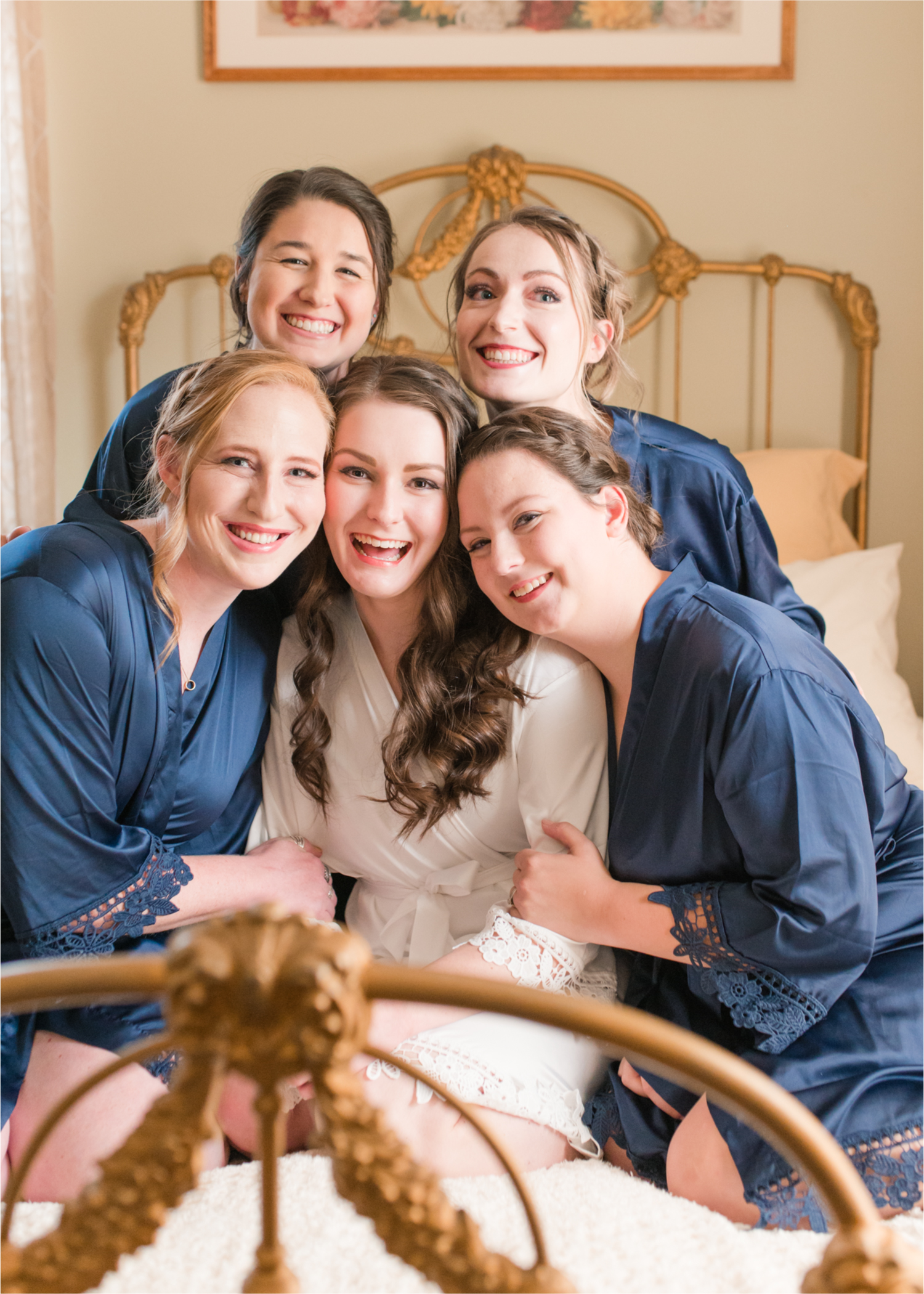 Summer Ellis Ranch Wedding in Loveland Colorado | Britni Girard Photography | Wedding Photo and Video Team | Bride hair Dondi AtWow from Sola Salon in Loveland | Getting Ready at Air BnB | Bride and bridesmaids in dark blue robes on bed